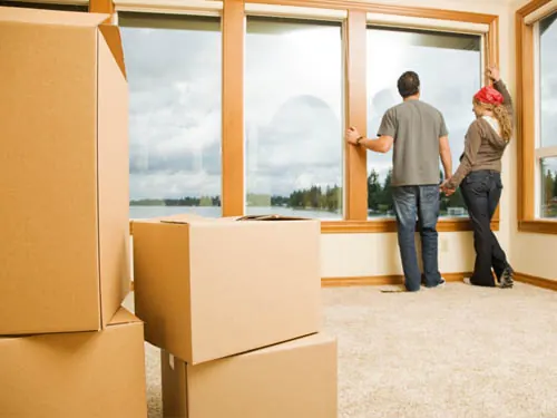 Casal analisando a janela do apartamento para planejar o içamento de móveis