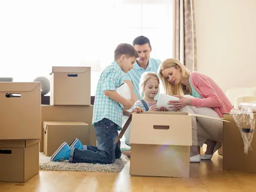 Família embalando objetos em caixas de papelão